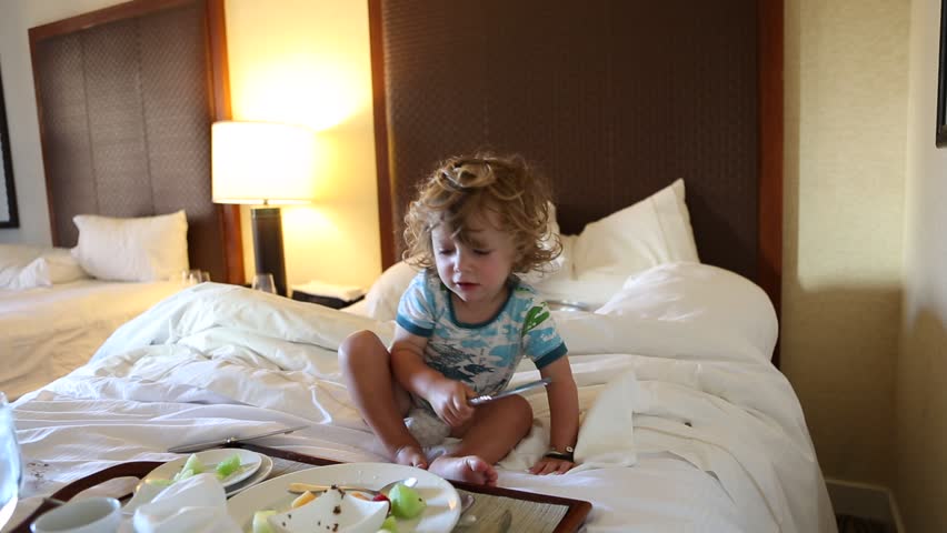 9 year old girl and 2 year old toddler boy having breakfast in hotel room
