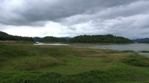 Tropical Fresh Water Lake. A cloudy sky over a tropical lake. A few tropical birds fly in and out of the scene.