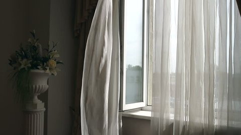 Curtain fluttering in the wind at the window. Wind at the window. A breath of wind. Open window. Curtain fluttering. The inside of the house. Interior of the house. Inspiration.