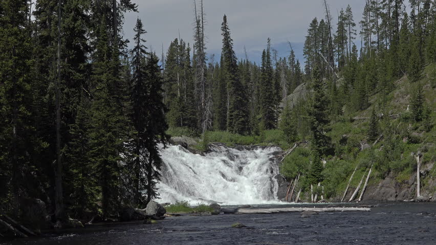 Yellowstone Lewis Falls waterfall river nature 4K. Rivers and lakes within the National Park. Maddison, Firehole, Gibbon, Lewis rivers. 3 million visitors from worldwide come to Yellowstone tourists.