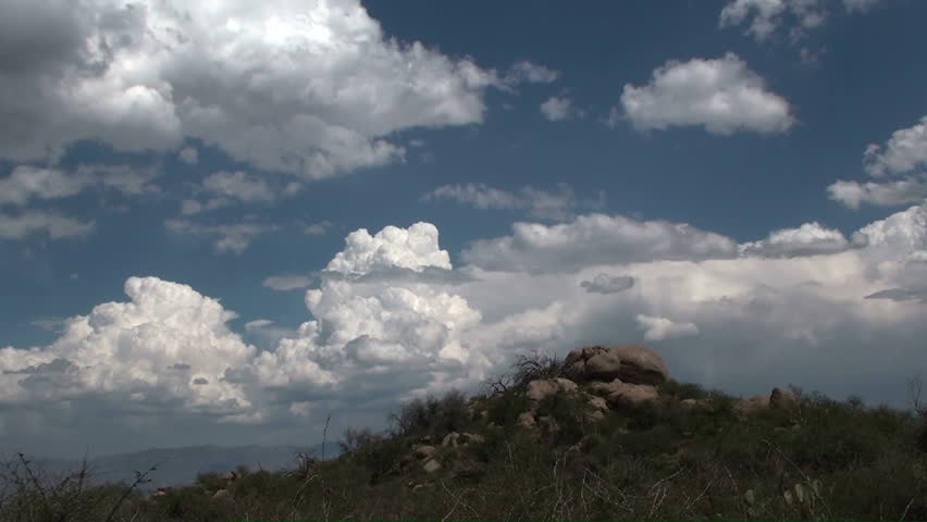 Time Lapse, Gorgeous, fluffy clouds roll over rocky, desert landscape.
