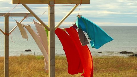 Colourful towels waving on wind by seashore, slow motion shot at 240 fps
