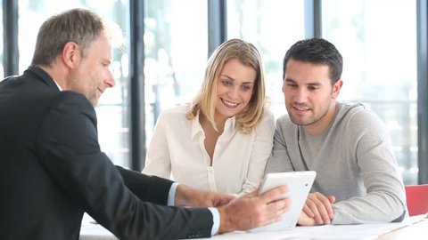 young couple meeting real estate agent for future house