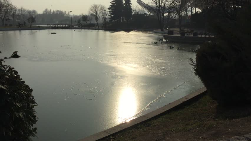 Ice layer on the lake and park view.