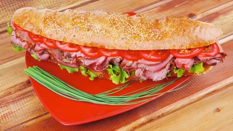 french sandwich : fresh white baguette with chicken smoked sausage on red ceramic plate over wooden table 1920x1080 intro motion slow hidef hd