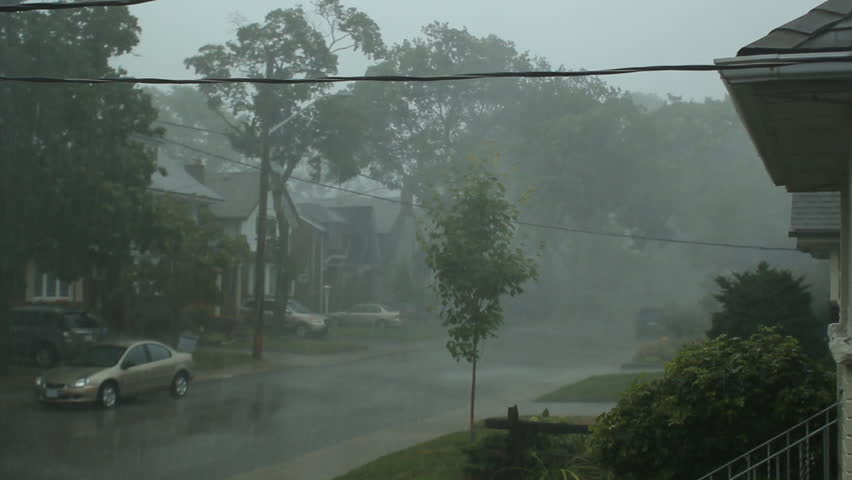 Scary suburban storm. Very strong summer storm with close to hurricane force winds. Thunder and lightning. Car drives down the street. East York, Ontario, Canada. 