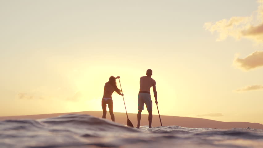 Slow Motion Couple Stand Up Paddle Boarding At Sunset 
