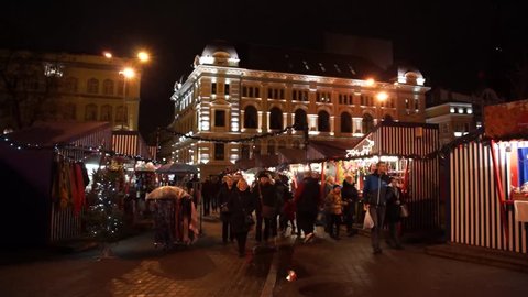 RIGA, LATVIA - DECEMBER 19, 2015: People visit Christmas Fair in old town at evening on December 15, 2015 in Riga, Latvia