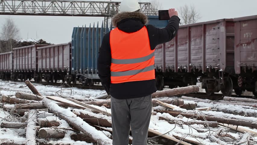 Engineer filmed on the tablet PC near the freight wagons