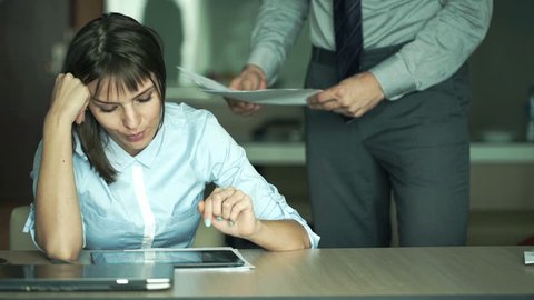 Sad, unhappy businesswoman getting rebuke from her boss 
