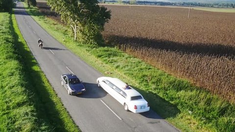 White limousine passing by. Top view recorded by drone from the sky. 