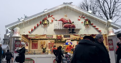 PARIS, FRANCE - CIRCA 2015: Tilt-down to Christmas Market with diverse chalet Christmas stall selling food and mulled wine on Champs-Elysees with friends buying souvenirs and food