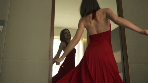 Young, beautiful woman checking her appearance in front of the mirror
