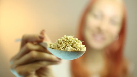 Fresh Green Sprouts Buckwheat in the spoon Closeup. Young Beautiful Woman Eating Sprouts Buckwheat. Raw Healthy Organic Diet. Healthy Vegetarian Eco Food concept, Dieting