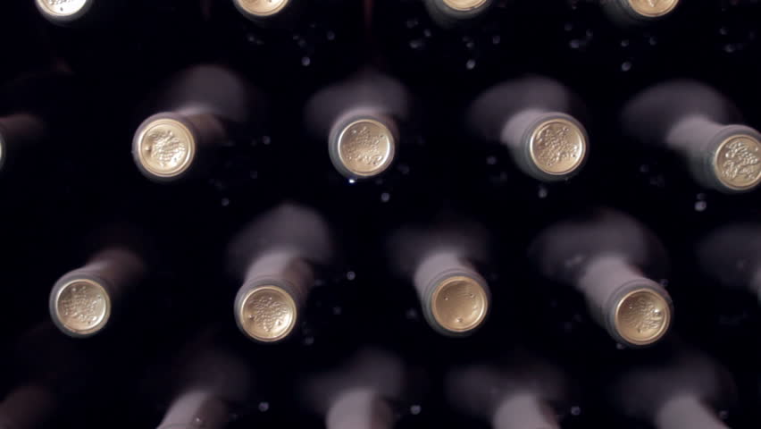 Dolly shot of wine bottles in an old wine cellar.