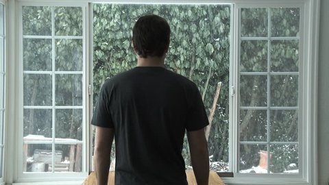 man looking out window watching heavy Stock Footage Video (100% Royalty ...