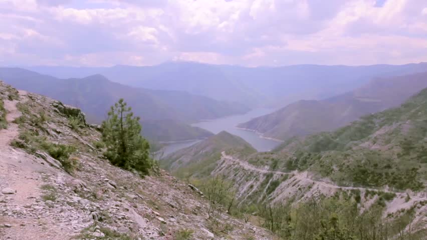 Man hiking on a rocky terrain with beautiful scenery. Dolly shot 