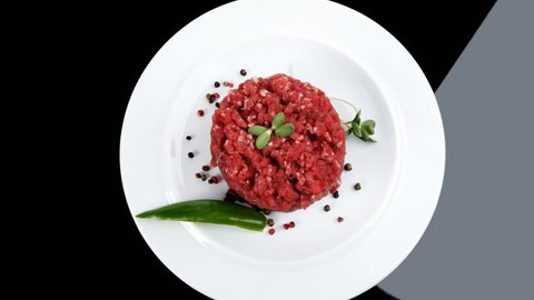 very big raw hamburger cutlet with sprouts and chilli pepper plate over black background 1920x1080 intro motion slow hidef hd