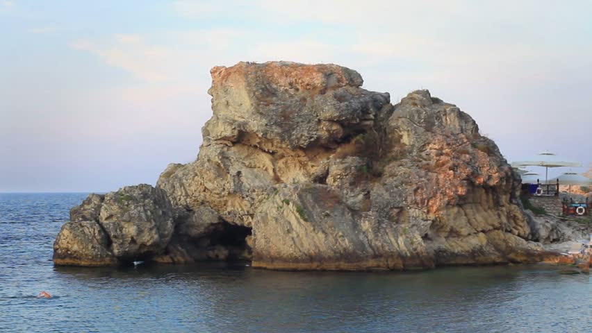 Man swimming beside rocky formation in Black Sea 