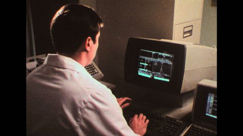 UNITED STATES 1980s: Man working on computer / View of computer screen / Close up, man's eyes / View of computer screen.