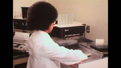 UNITED STATES 1980s: Woman puts vials in testing equipment / Samples in machine / Woman with test equipment / Close up of printed readout.