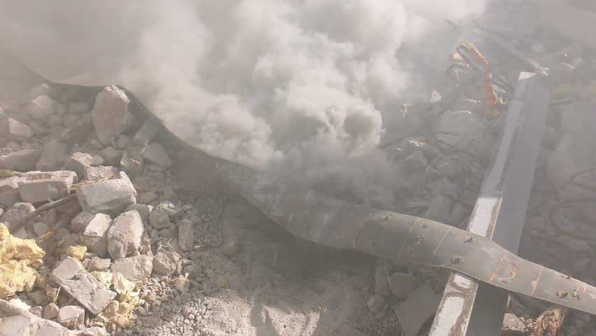 Smoke comes out of the rubble as a result from earthquake rocket attack tsunami demolition Royalty-Free Stock Footage #13695020