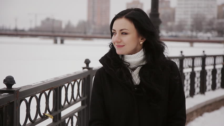 beautiful girl goes over the bridge winter river
