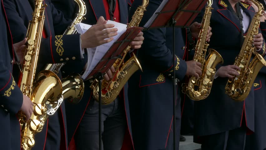 Ungraded: Brass Band performs jazz in the open air. Musicians leaf sheet music on the desk. Source: Lumix DMC, ungraded H.264 from camera without re-encoding. (av14263u)
