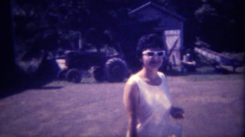 DES MOINES, IOWA 1963: Modern urban women visits her childhood tractor farm.