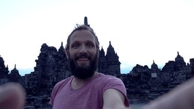 Man taking selfie photo by Prambanan temple, super slow motion
