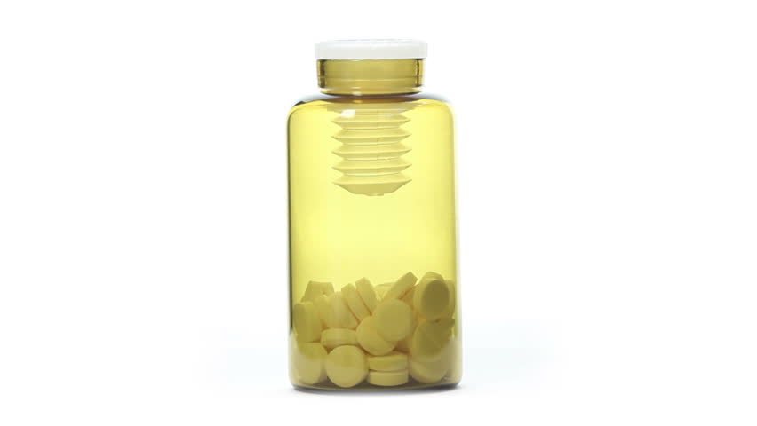 rotating jar of pills on white background. closeup