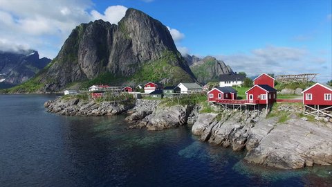 Aerial footage of small fishing village of Hamnoya on Lofoten islands in Norway, popular tourist destination with its typical red houses and natural beauty. Aerial 4k Ultra HD.