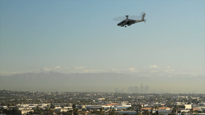 An AH-64 Apache attack helicopter flying over Los Angeles and directly at the
