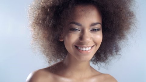 Portrait of a beautiful cheerful young African woman smiling over white background.