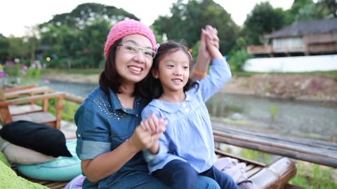 Footage mother enjoy dancing with daughter beside beautiful river