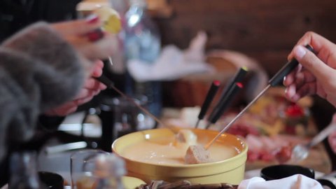 Man dips bread in cheese fondue