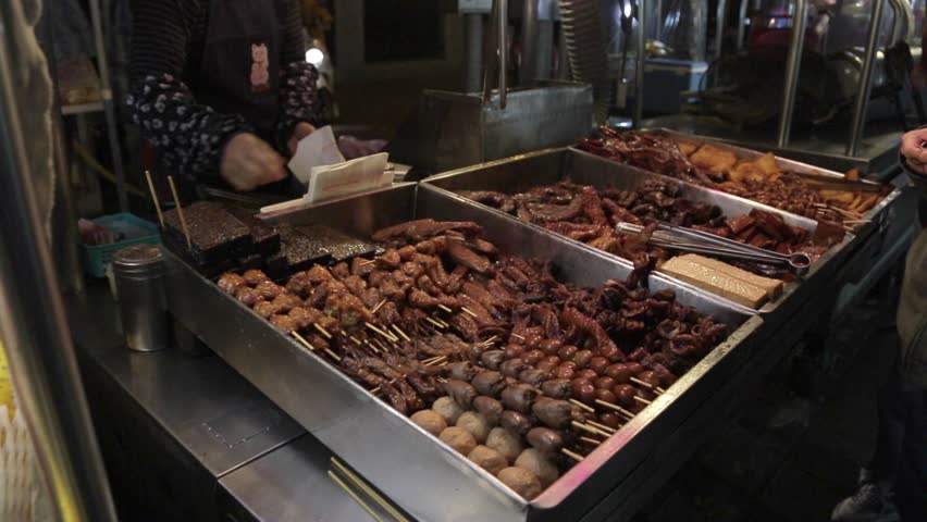 Exotic foods for sale at Chinese night market in Taiwan. Street vendors cook Chinese food for tourists and shoppers.
