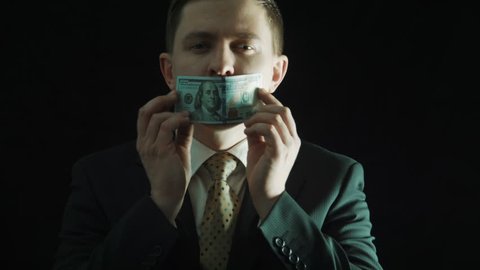 The politics in a suit closes mouth with the hundred-dollar banknote