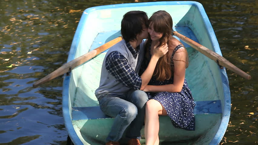 A young couple kissing in a boat