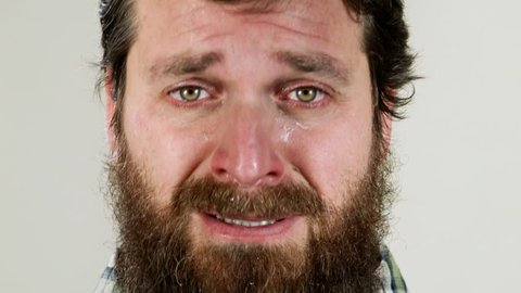 Extreme close up of hipster crying against neutral background