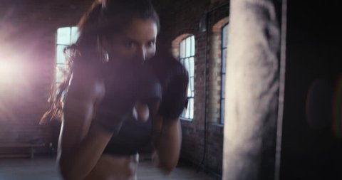 Beautiful Kickboxing woman training punching bag in fitness studio fierce strength fit body kickboxer series