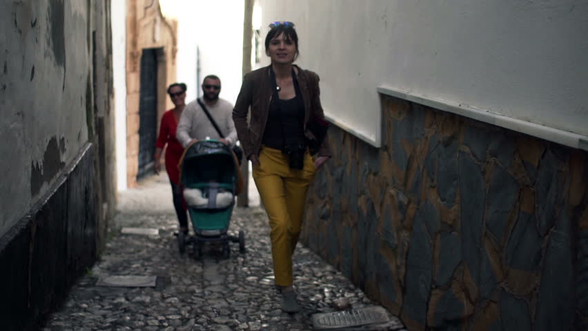 People walking through narrow street in the city 
