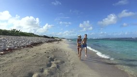 Cheerful couple running on sandy beach in Caribbean island
