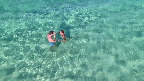 Aerial view of couple swimming in caribbean sea