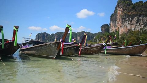 KRABI, THAILAND - Beautiful traditional Thai long tail tourist boats moored at Railay beach, Krabi.