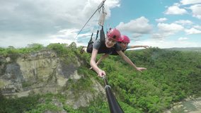 Stunning footage of a couple sliding down a zipline, zip-line, thy are quite shocked when they leave the forest and fly over the canyon. Part one, filmed of a selfiestick. - Powered by Shutterstock - Get 15% off with code: PIKWIZARD15