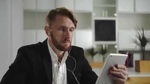 Businessman talking to a tablet