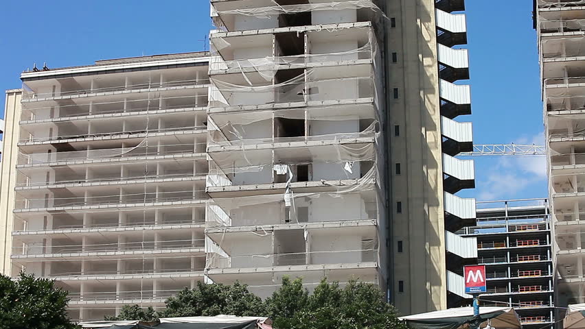 Crane in action in back of crumbling building