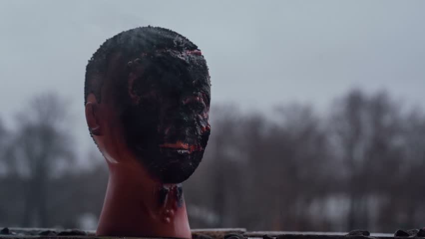 Black burned mannequin head close up.