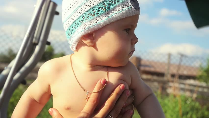  Slow motion  of a small smiling baby boy swinging on a backyard swing in a hot summer day.